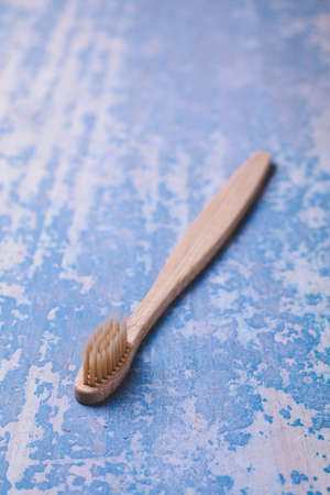 Bamboo toothbrush on blue wood background. Concept eco friendlyの写真素材