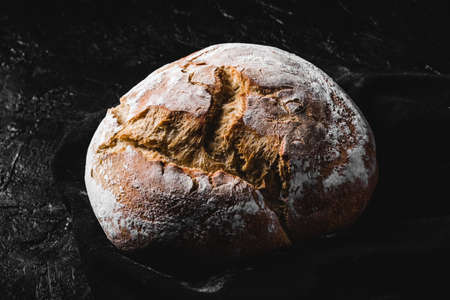 dark homemade bread dusted with flourの写真素材