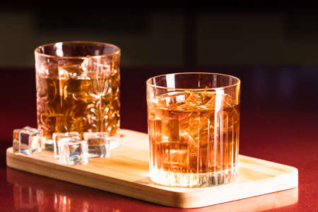 Whiskey glasses with ice in a lounge barの写真素材