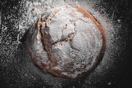 dark homemade bread dusted with flourの写真素材