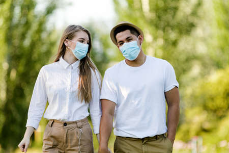 Couple with protective mask walking in the parkの写真素材