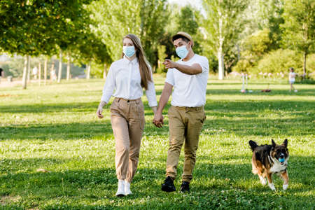 Couple with protective mask walking in the parkの写真素材