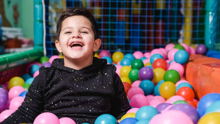 happy 5 year old boy with mask in a ball pool so happyの写真素材