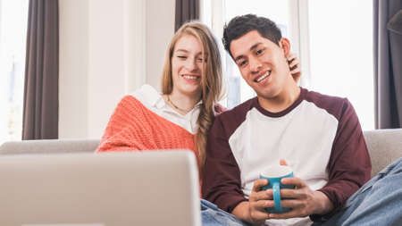 Portrait of a young couple on a video call with their laptop while staying at home.の写真素材
