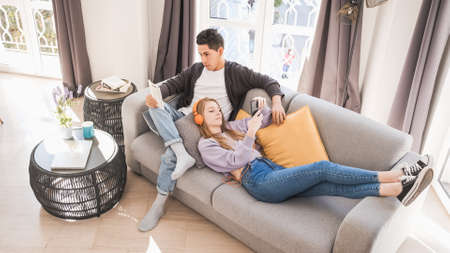 Young couple relaxing and spending time together on the couch while staying at home.の写真素材