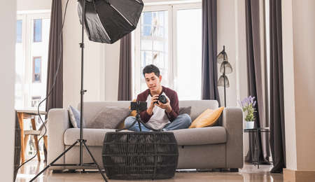 Young blogger man creating content for social media while making a video at home.の写真素材