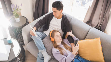 Young couple relaxing and spending time together on the couch while staying at home.の写真素材