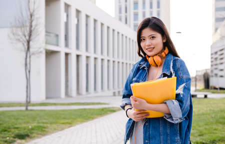 Portrait of an Asian student standing outdoors on college campus. Education concept.の写真素材