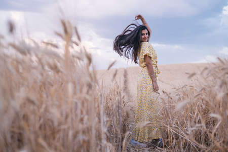 Young carefree woman enjoying nature while posing in a wheat field.の写真素材