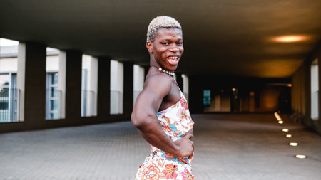 Smiling black transsexual guy in dress looking at camera on streetの写真素材