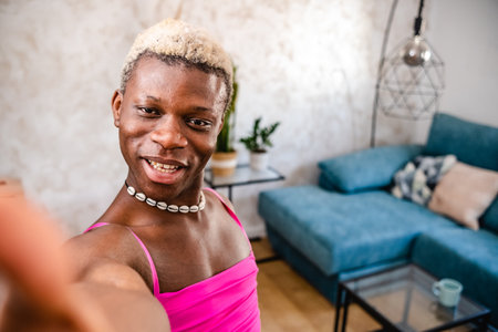 Joyful black transsexual woman showing her apartment to cameraの写真素材