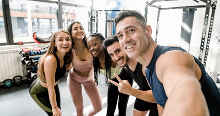 Cheerful diverse sportspeople doing selfie at gymの写真素材