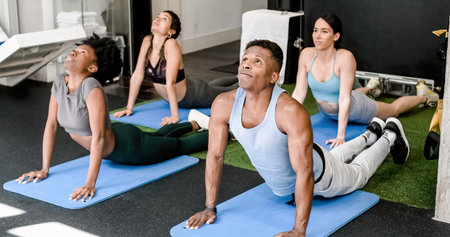 Group of multiethnic people doing stretching exercise on matsの写真素材