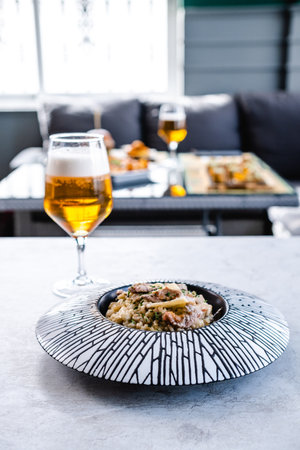 Plate with risotto near glass of beerの写真素材