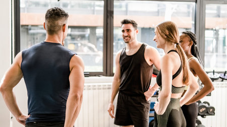 Cheerful middle-aged and young friends hugging in gymの写真素材