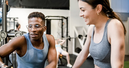 Fit trainer explaining exercise to woman in gymの写真素材
