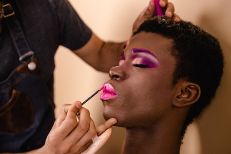 Makeup artist doing makeup on an African transgender person.の写真素材