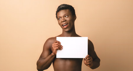 Smiling black young male model with blank posterの写真素材