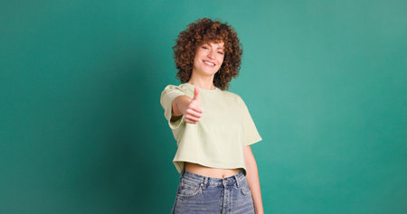 Adult woman on studio giving a thumbs up gestureの写真素材