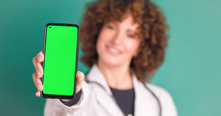 Happy crop woman doctor showing chromakey on smartphone