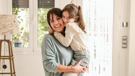 Mother and girl embracing and smilingの写真素材