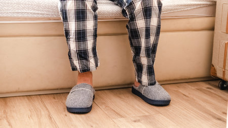 Person putting on slippers when getting out of bed in pyjamasの写真素材