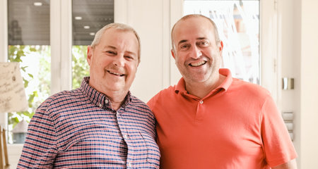 Mature gay couple standing together and smilingの写真素材
