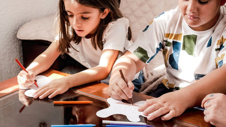 Children doing crafts at home with their motherの写真素材