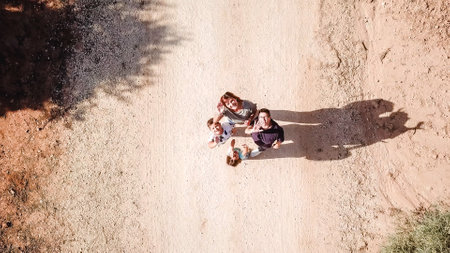 Drone lifting as a family waves to the camera in the middle of a pathの写真素材