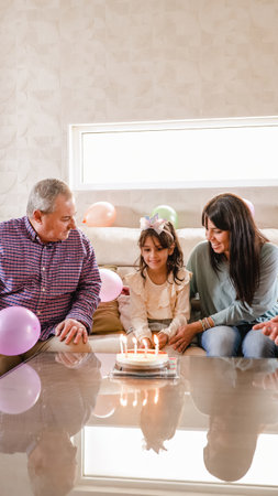 Gay couple with daughter celebrating granddaughter birthdayの写真素材