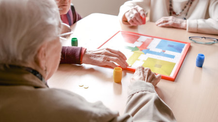 Senior friends playing ludo board game in nursing homeの写真素材