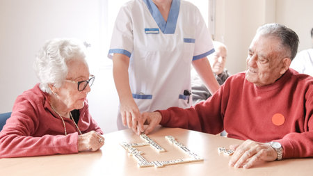 Nurse playing dominoes with senior people in nursing homeの写真素材