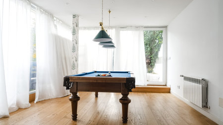 Pendant lights over billiard table in game room at home