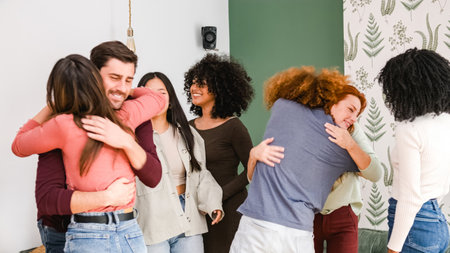 Multiethnic excited friends embracing each other during weekend party at homeの写真素材