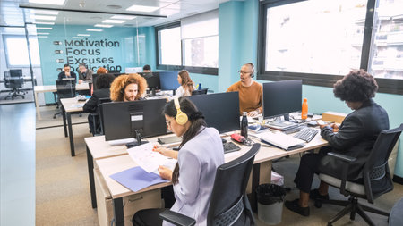 Busy businesspeople working at computer desks in creative officeの写真素材