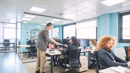 Manager giving file to employee in coworking workspaceの写真素材