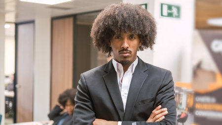 Arrogant creative businessman standing with arms crossed in officeの写真素材