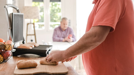 Unrecognizable man cutting bread on chopping boardの写真素材