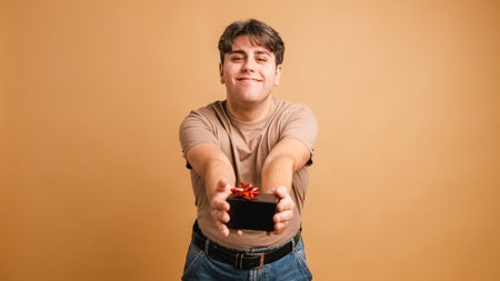 Happy man giving present and looking at cameraの写真素材