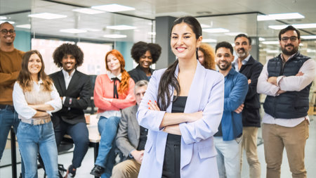 Contented businesswoman with team in background at creative office