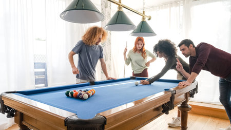 Multiethnic friends playing pool together in game room at home