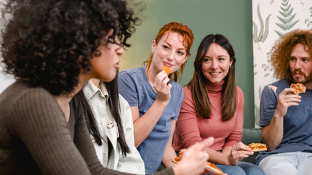 Smiling woman looking at while eating nacho chip during weekend partyの写真素材