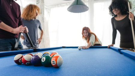 Male and female friends playing pool together in game room at home