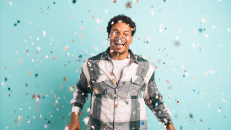 Cheerful man celebrating big win showered in confetti