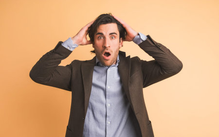 Stunned businessman with opened mouth in brown studioの写真素材