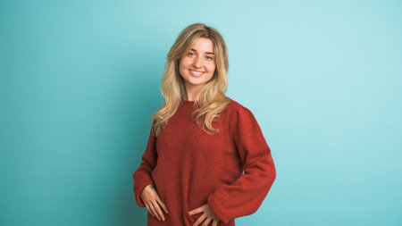 Happy woman laughing at camera in blue studioの写真素材