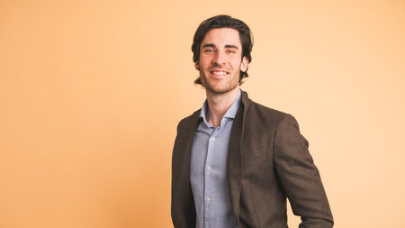 Smiling man in jacket looking at camera in brown studio