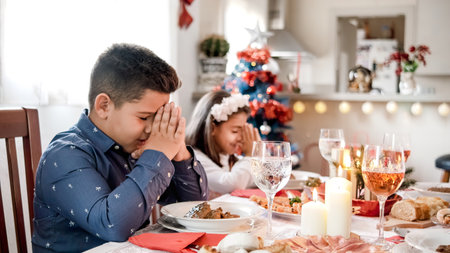 Two kids praying before Christmas mealの写真素材