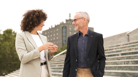 Smiling business people talking on stairs in city