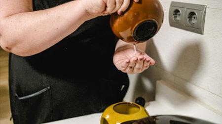 Beautician pouring liquid into aroma lamp in beauty salonの写真素材